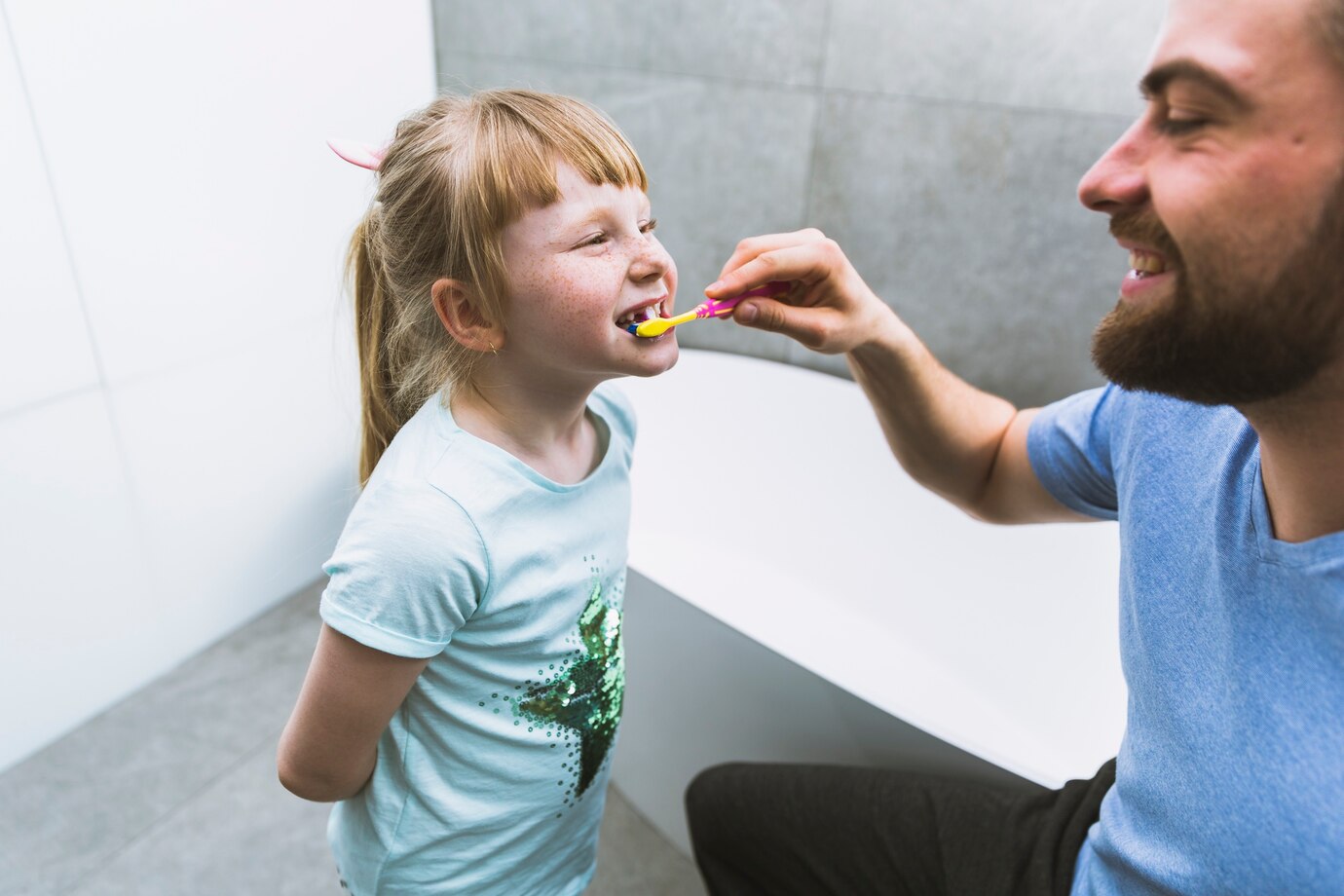 Enfant qui se brosse les dents avec les parents